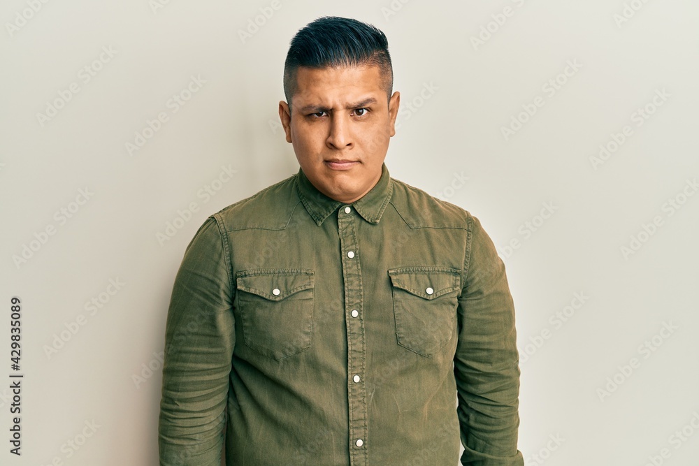 Young latin man wearing casual clothes skeptic and nervous, frowning upset because of problem. negative person. Young latin man wearing casual clothes skeptic and nervous, frowning upset because of problem. negative person.