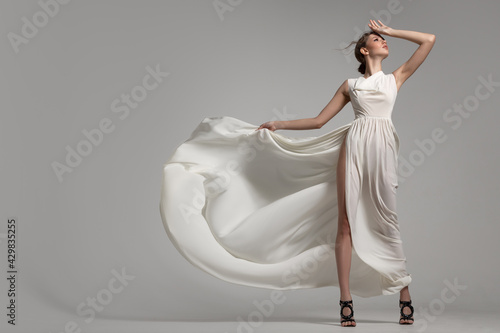 Bilde på lerret Fashion woman portrait in white long flying airy dress