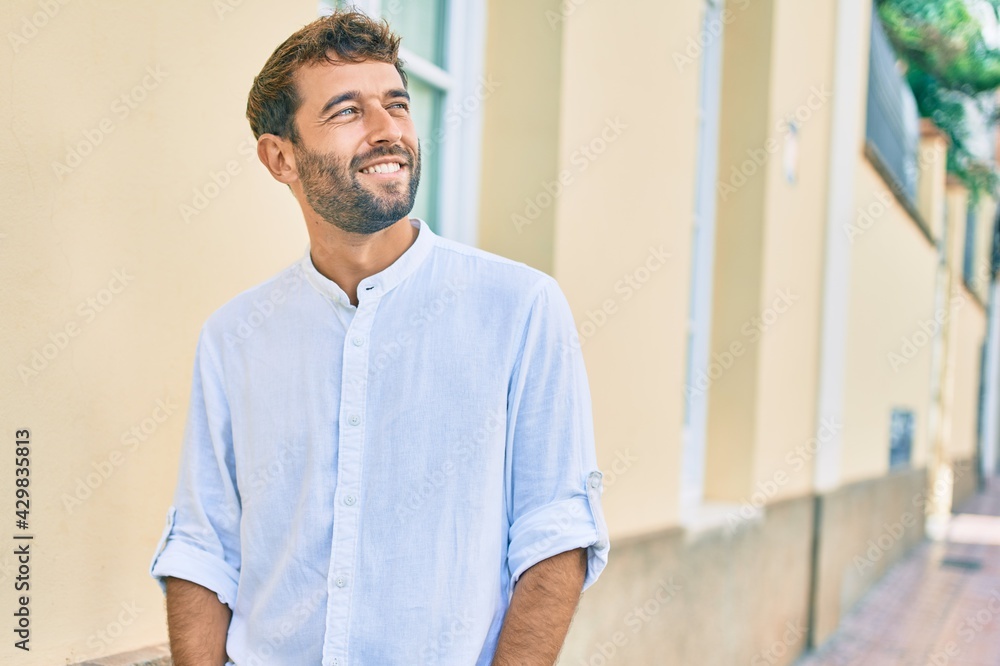 Handsome man with beard wearing casual white shirt on a sunny day smiling happy outdoors Handsome man with beard wearing casual white shirt on a sunny day smiling happy outdoors