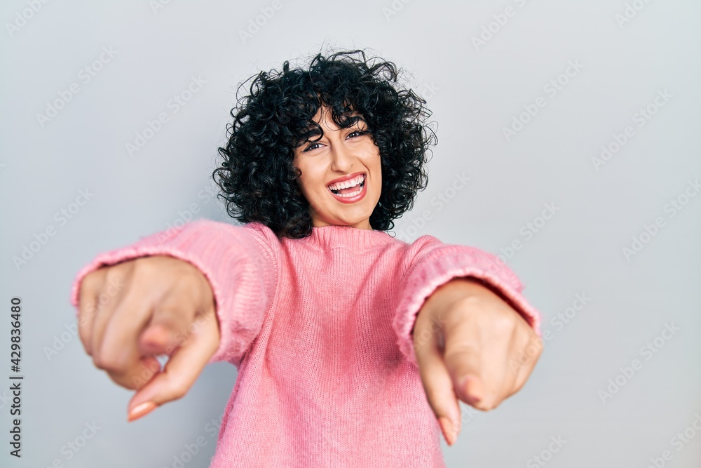 Young middle east woman wearing casual clothes pointing to you and the camera with fingers, smiling positive and cheerful Young middle east woman wearing casual clothes pointing to you and the camera with fingers, smiling positive and cheerful