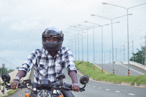 African biker in the helmet riding a motorcycle rides on highway road © arrowsmith2