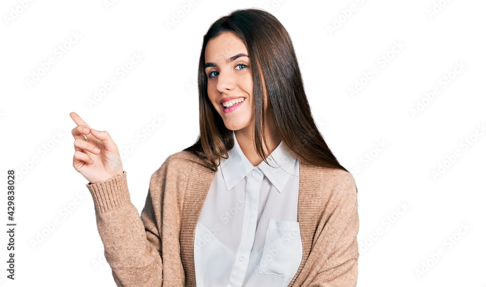 Young brunette teenager wearing casual white shirt and jacket smiling happy pointing with hand and finger to the side Young brunette teenager wearing casual white shirt and jacket smiling happy pointing with hand and finger to the side