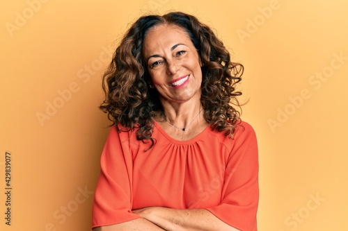 Middle age hispanic woman wearing casual clothes happy face smiling with crossed arms looking at the camera. positive person. © Krakenimages.com