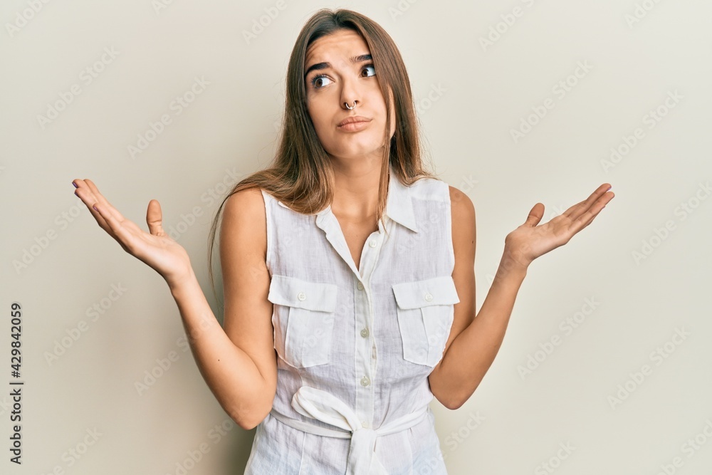 Young hispanic woman wearing casual clothes clueless and confused with open arms, no idea and doubtful face. Young hispanic woman wearing casual clothes clueless and confused with open arms, no idea and doubtful face.