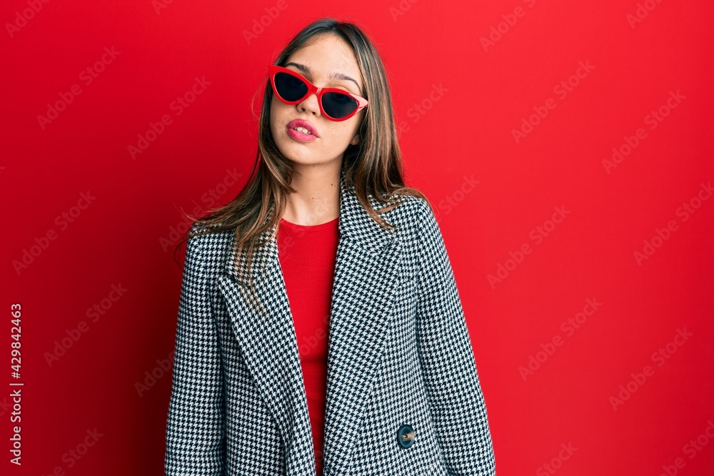 Young brunette woman wearing fashion and modern look relaxed with serious expression on face. simple and natural looking at the camera. Young brunette woman wearing fashion and modern look relaxed with serious expression on face. simple and natural looking at the camera.