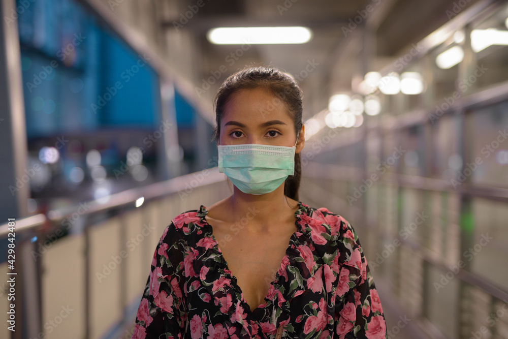 Portrait of woman wearing face mask for protection against coronavirus Covid-19 at night