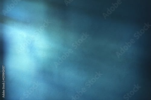 Abstract blue wall texture. Illuminated by beams of light. Empty room scene.