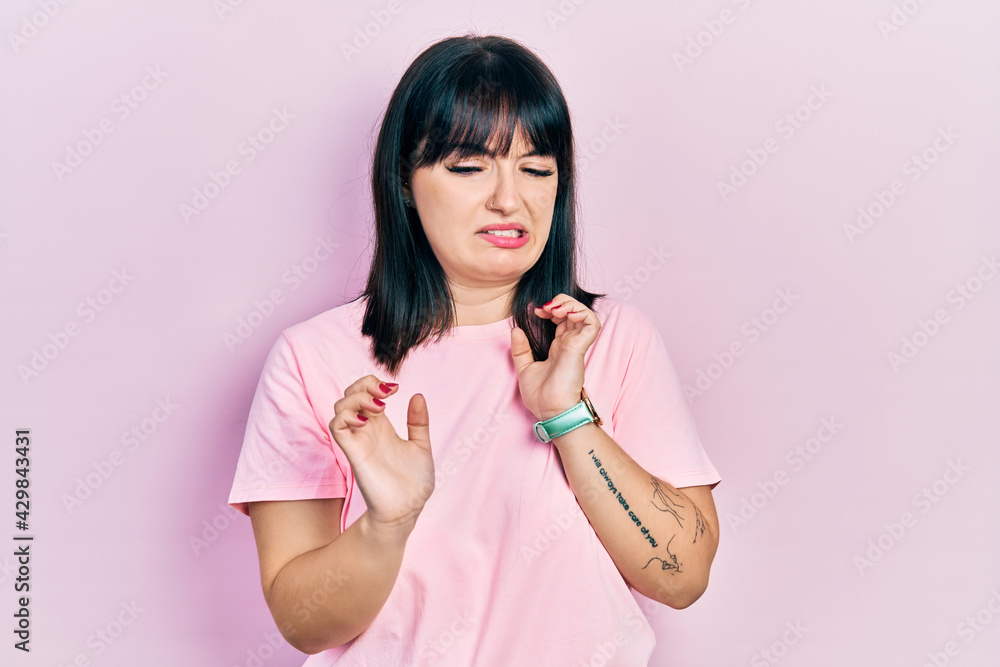 Young hispanic woman wearing casual clothes disgusted expression, displeased and fearful doing disgust face because aversion reaction. Young hispanic woman wearing casual clothes disgusted expression, displeased and fearful doing disgust face because aversion reaction.