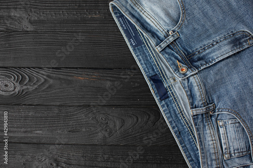 Blue jeans on a wooden background, texture of denim. Top view.