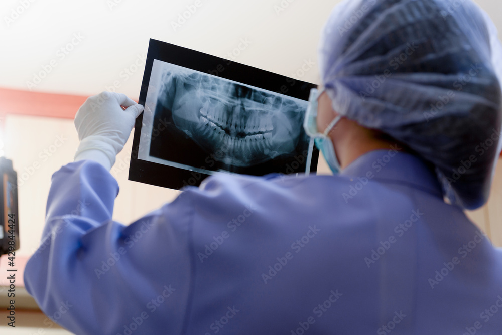 Dentist woman holding to show orthodontist x-ray picture in dentist's office Dentist woman holding to show orthodontist x-ray picture in dentist's office