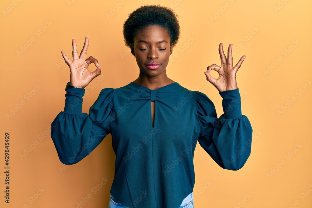 Young african american girl wearing casual clothes relax and smiling with eyes closed doing meditation gesture with fingers. yoga concept.
