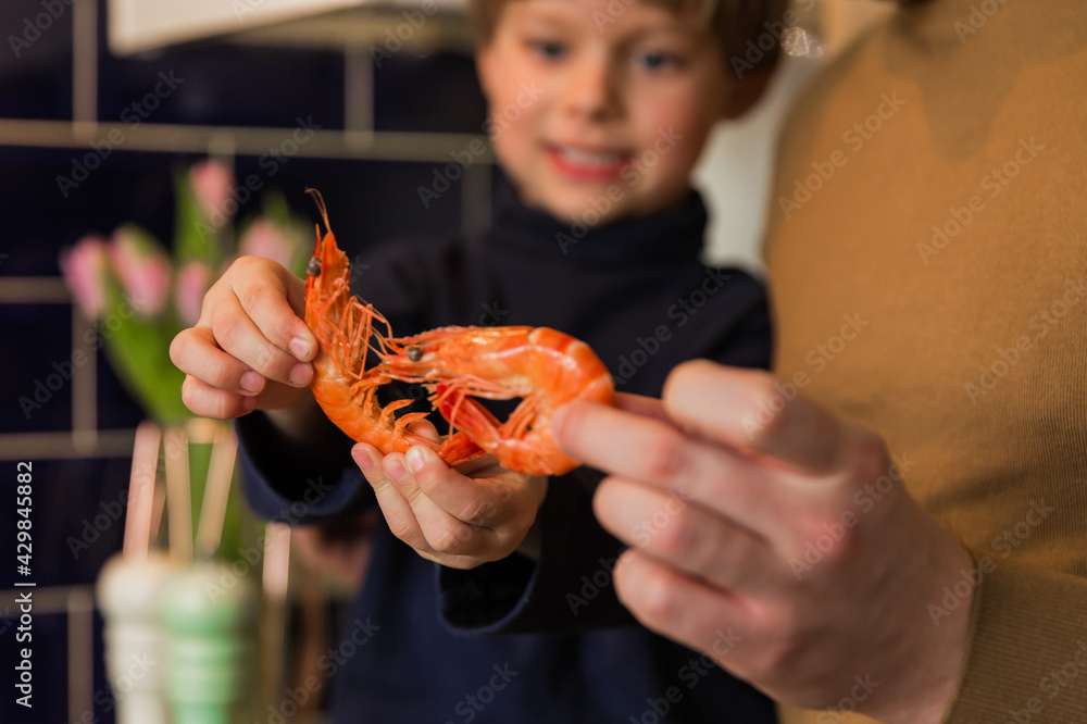 A happy family. Dad and young son holding shrimp in their hands. Seafood.