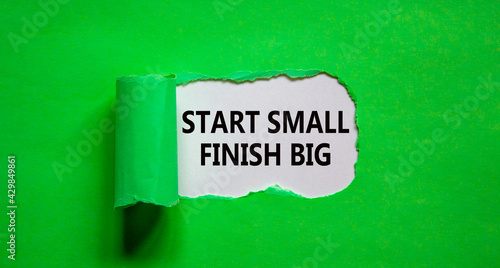 Start small finish big symbol. Concept words 'Start small finish big' appearing behind torn green paper. Business, motivational and start small finish big concept.