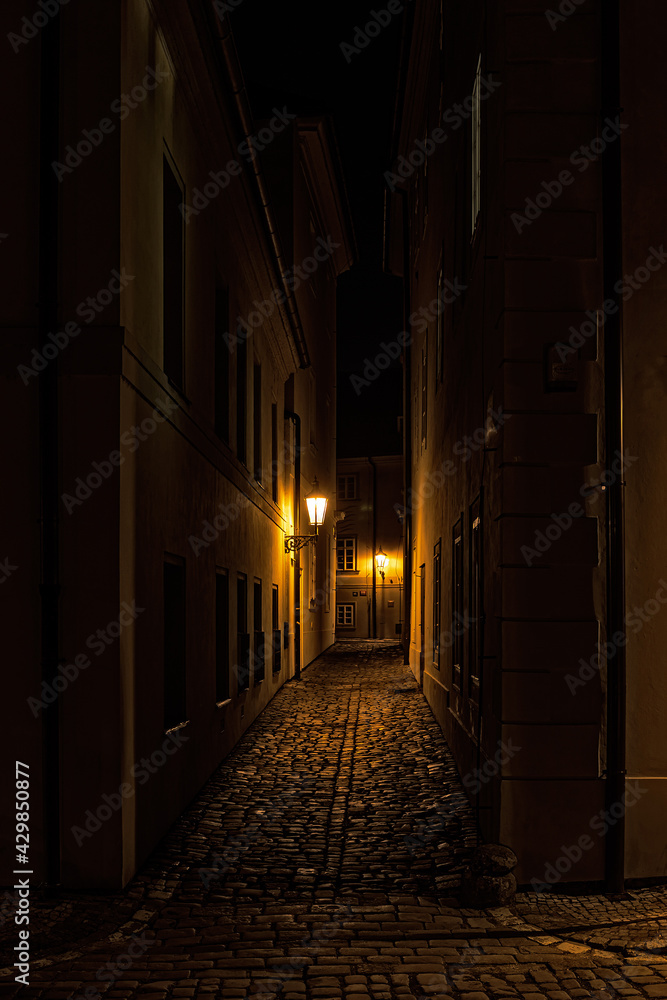 small street at night in old Prague in the historical center with old lamps
