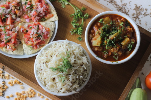 Indian dish made of basmati rice flavoured with cumin seeds and spices. Served with Bottle Gourd Curry with Lentils and Crisp and fried papads topped with masala filling photo