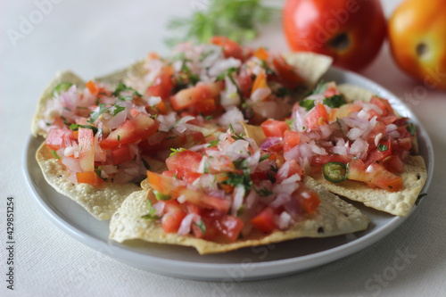 Crisp and fried papads topped with a masala filling of onions, tomatoes and spices. Popular starter from North India commonly known as masala papad. photo