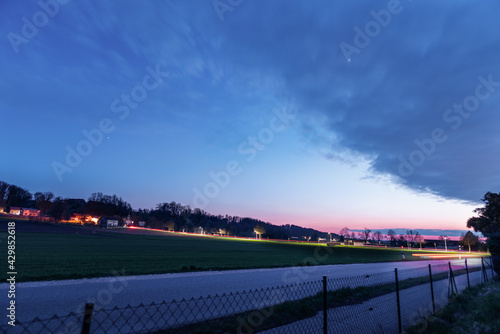 Landschaft  in Bayern mit Hügel und Wald beim Sonnenuntergang / Blauer stunde, mit Straße, Regenwolken und  Zaun © H. Rambold