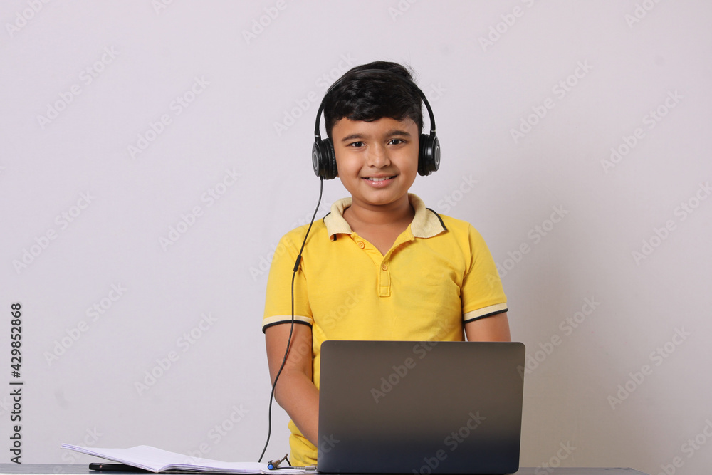 Indian syudent or kid attending online school using computer studying using laptop. Indian syudent or kid attending online school using computer studying using laptop.