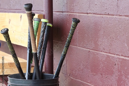 Bucket of baseball bats in the dugout
