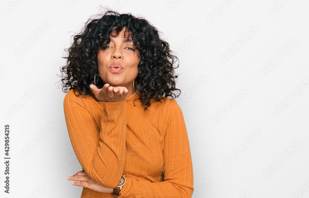 Young hispanic woman wearing casual clothes looking at the camera blowing a kiss with hand on air being lovely and sexy. love expression. Young hispanic woman wearing casual clothes looking at the camera blowing a kiss with hand on air being lovely and sexy. love expression.