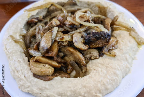 Traditional Mediterranean hummus with mushrooms and onions.