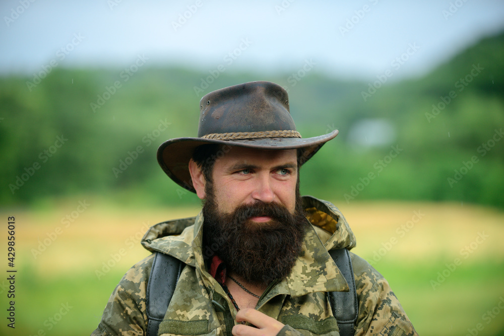 Hunting season. Animal Hunt. Brutal man poacher. Male adventures. Beard guy hiking with backpack. Mature hunter, hunting season. soldier in military uniform.