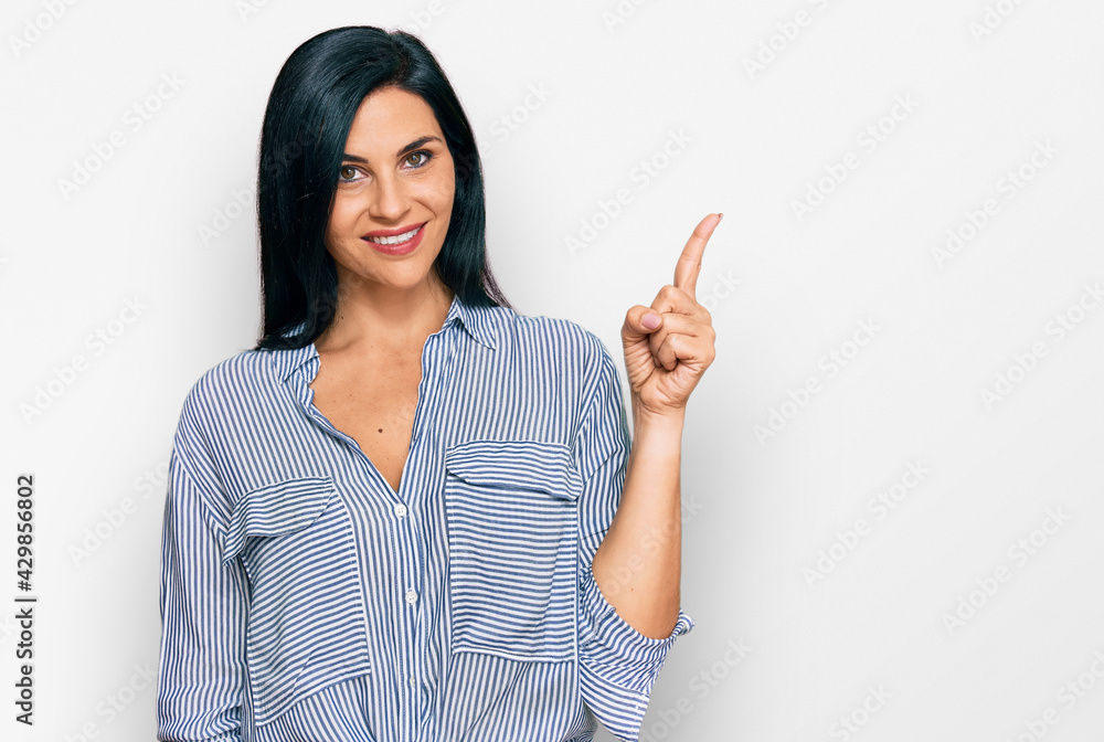 Young caucasian woman wearing casual clothes pointing finger up with successful idea. exited and happy. number one. Young caucasian woman wearing casual clothes pointing finger up with successful idea. exited and happy. number one.