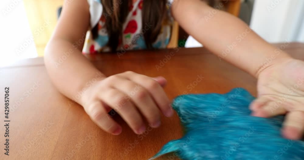 Child hands playing with slime goo. Little girl close-up hand and fingers with sticky elastic plasticine Child hands playing with slime goo. Little girl close-up hand and fingers with sticky elastic plasticine