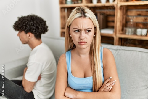 Young couple angry sitting on the sofa in silence at home.