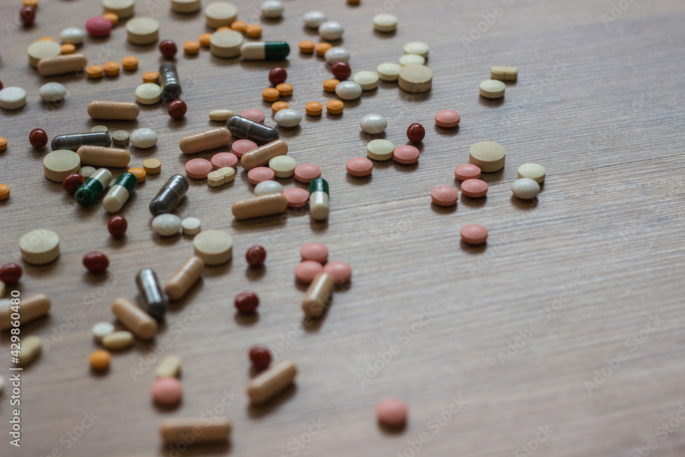 A photo of different medicinal drugs, tablets and pills on wooden background A photo of different medicinal drugs, tablets and pills on wooden background