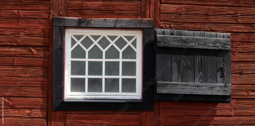 Old window with handmade glas panes on a 200 years old traditional red and black painted Scandinavian cottage Old window with handmade glas panes on a 200 years old traditional red and black painted Scandinavian cottage