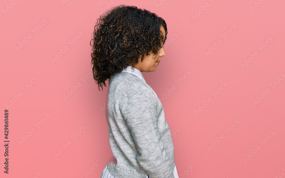 Young little girl with afro hair wearing casual clothes looking to side, relax profile pose with natural face with confident smile. Young little girl with afro hair wearing casual clothes looking to side, relax profile pose with natural face with confident smile.