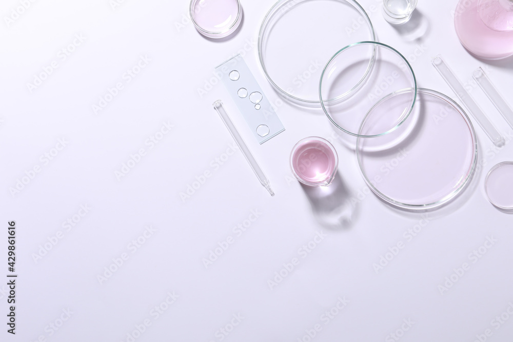 Organic cosmetic product and laboratory glassware on white background, top view. Space for text Organic cosmetic product and laboratory glassware on white background, top view. Space for text