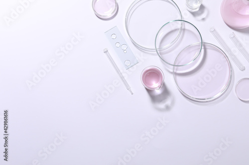 Organic cosmetic product and laboratory glassware on white background, top view. Space for text