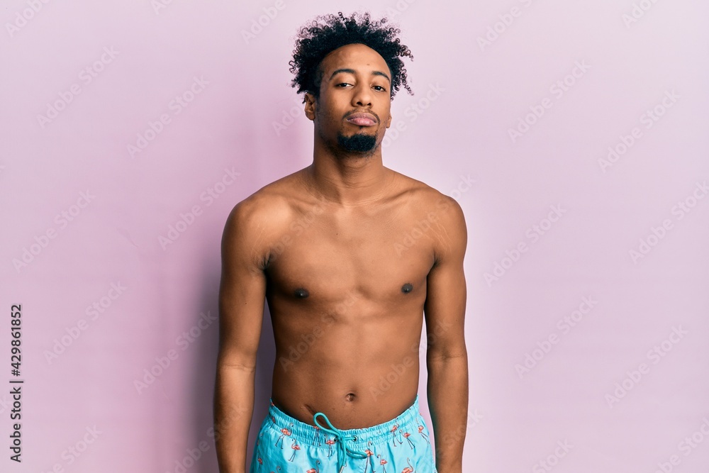 Fototapeta premium Young african american man with beard wearing swimsuit depressed and worry for distress, crying angry and afraid. sad expression.