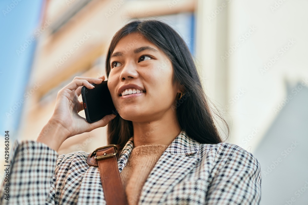 Young asian businesswoman smiling happy using smartphone at the city. Young asian businesswoman smiling happy using smartphone at the city.