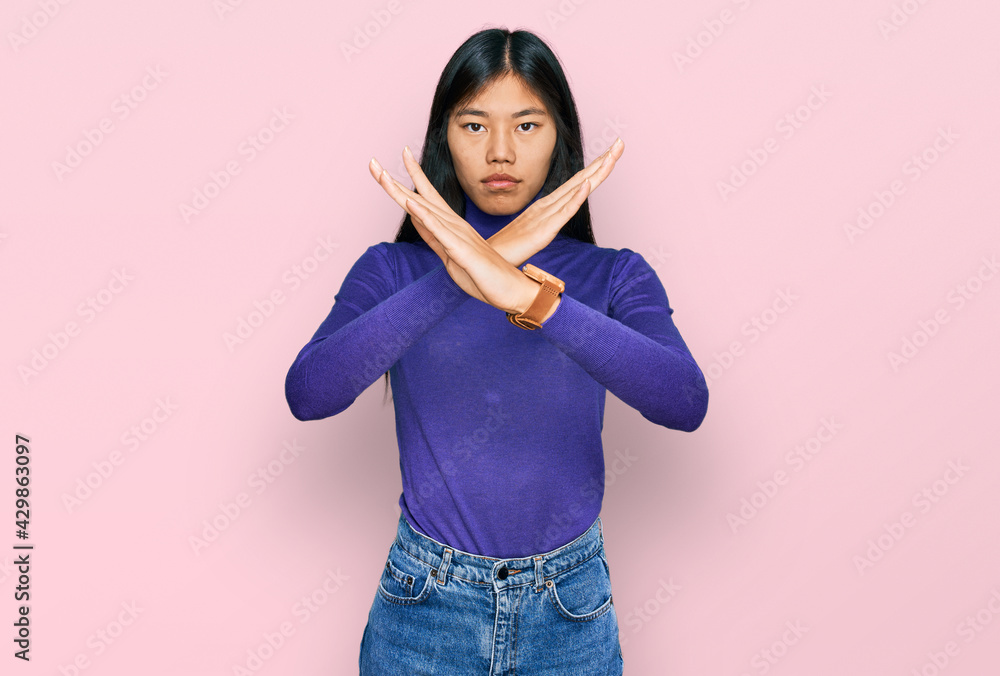 Beautiful young asian woman wearing casual clothes rejection expression crossing arms doing negative sign, angry face Beautiful young asian woman wearing casual clothes rejection expression crossing arms doing negative sign, angry face