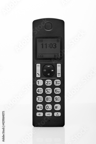 vertical receiver of a push-button telephone of black color on a white background photo