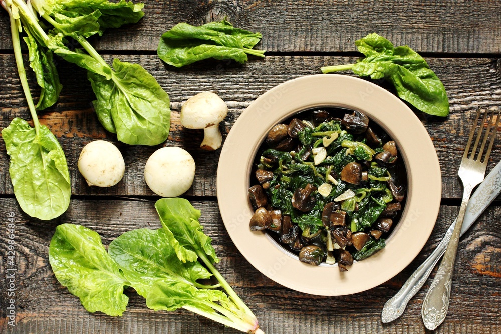 fried champignons with spinach in a plate.
top view. Copy space. fried champignons with spinach in a plate.
top view. Copy space.