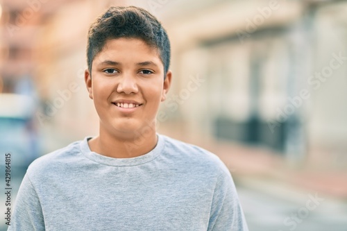 Adorable latin boy smiling happy standing at the city.