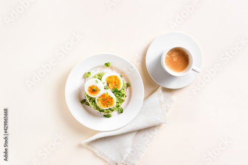 Avocado egg sandwich and cup of coffee
