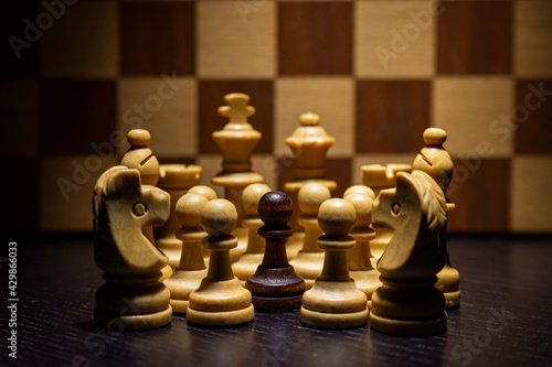 Todas las piezas blancas acosan a un peón negro con el tablero de fondo