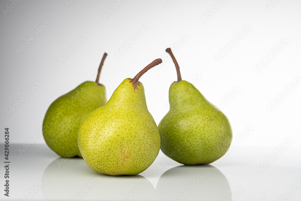 Pear, pakkham varieties, on a light background, with reflection Pear, pakkham varieties, on a light background, with reflection