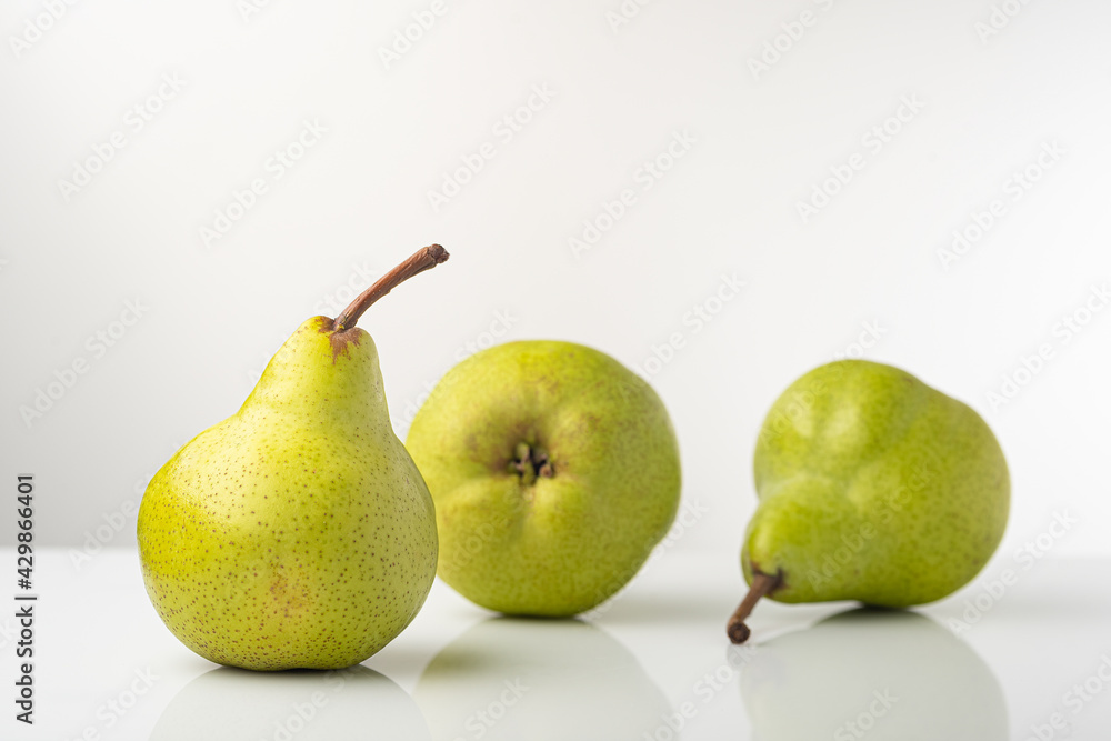 Pear, pakkham varieties, on a light background, with reflection Pear, pakkham varieties, on a light background, with reflection