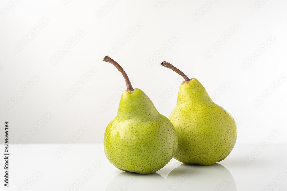 Pear, pakkham varieties, on a light background, with reflection Pear, pakkham varieties, on a light background, with reflection