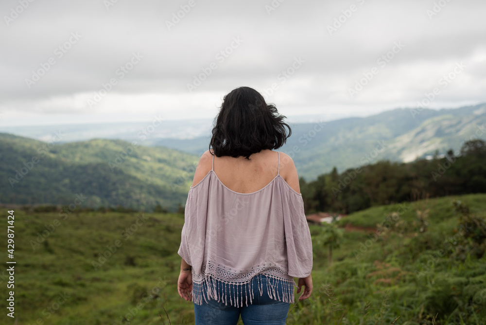 woman looking at the horizon in the field, woman in the mountains.