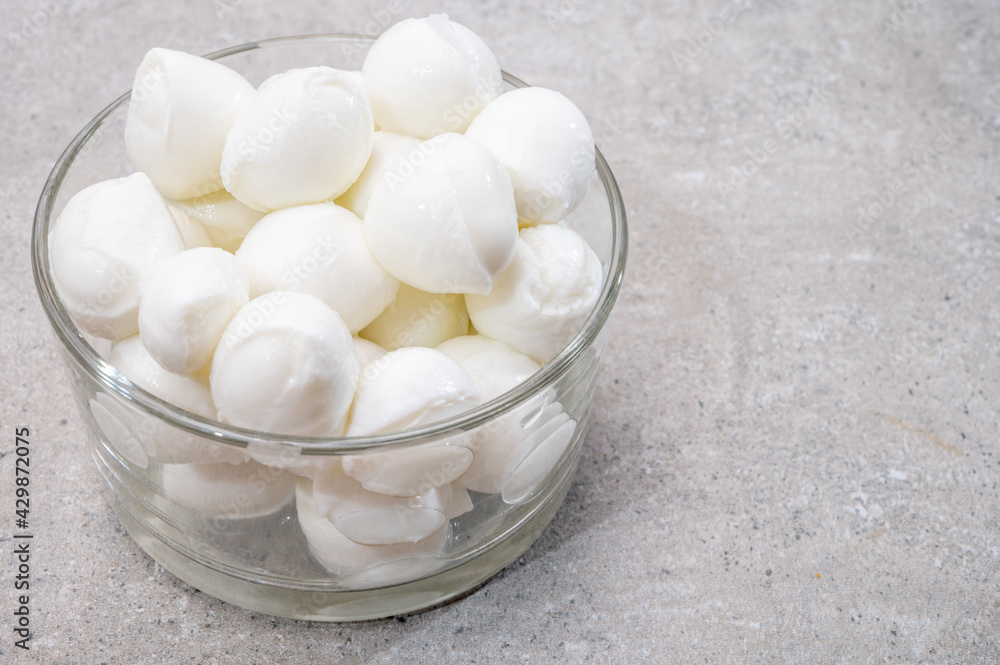 Cheese collection, small balls of fresh white soft Italian mozzarella cheese, ready for making caprese salad Cheese collection, small balls of fresh white soft Italian mozzarella cheese, ready for making caprese salad
