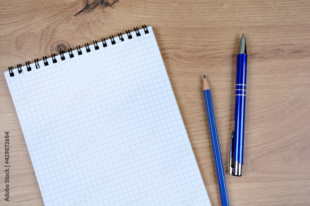 Empty notebook with pen and pencil on a wood table Empty notebook with pen and pencil on a wood table