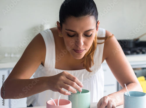 latina woman making candles in home photo