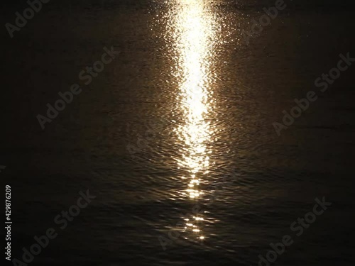 Beautiful sunset, sparkling sunny path on the sea or ocean water surface with waves. Time Lapse